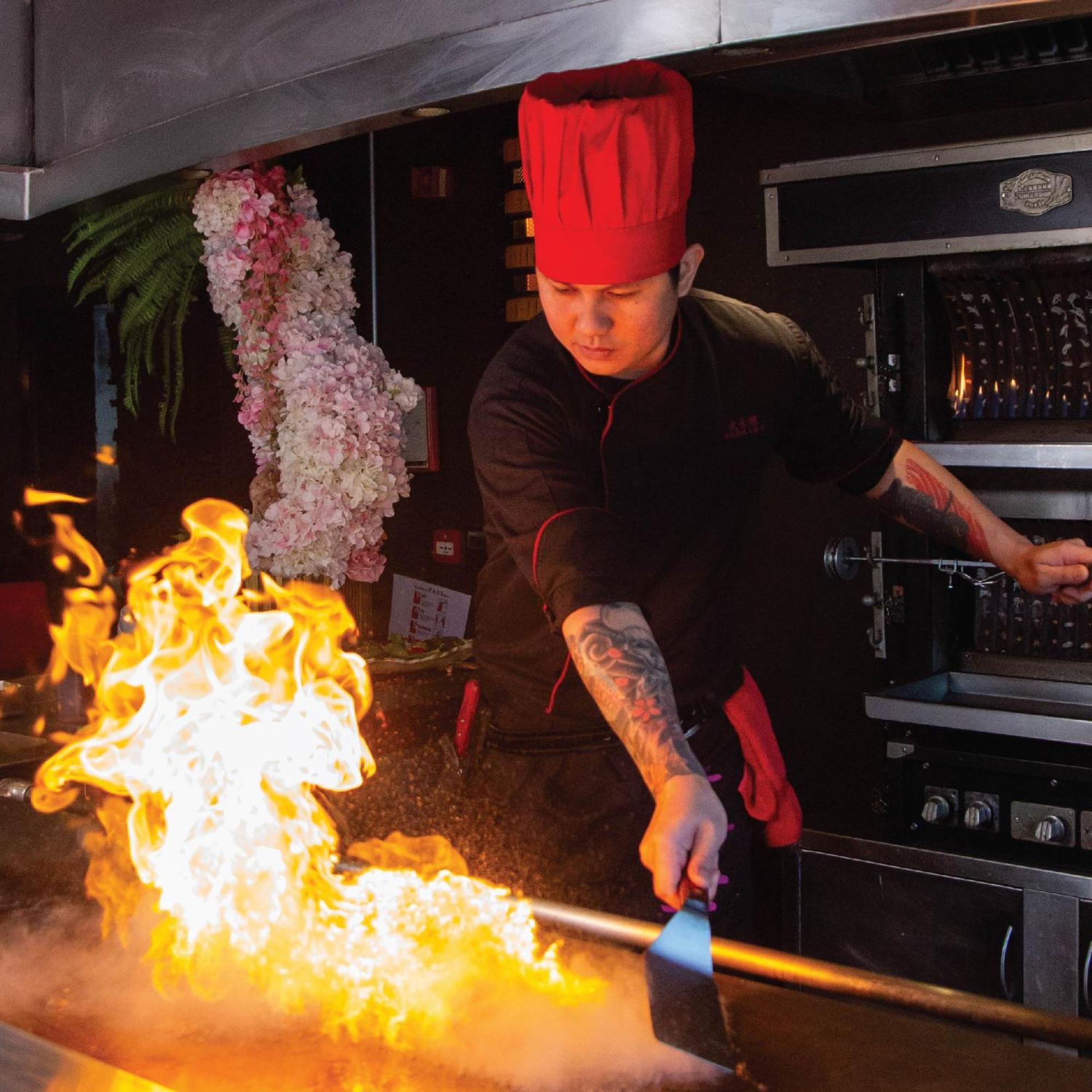 Royal Saray Resort Manama Exterior photo A chef cooking with a flaming torch